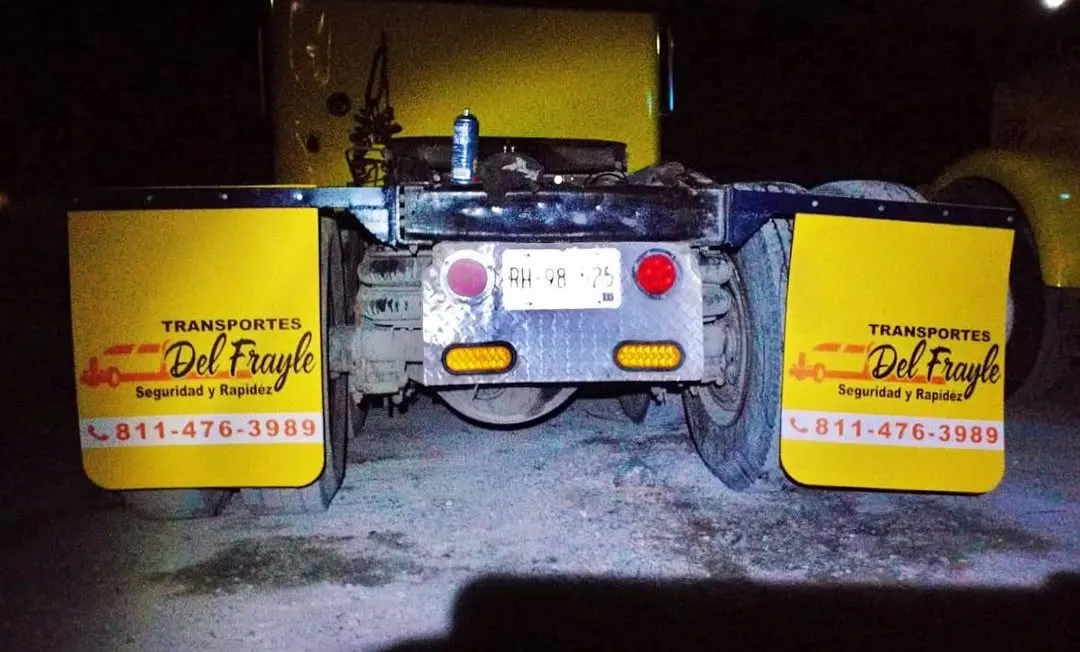 Loderas amarillas con logotipo de transportista y teléfono instaladas en un tractocamión, foto nocturna